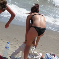 Sexy girl in black bikini dressing on the beach D_06.JPG