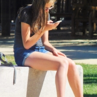 Bunch of candid babes in public in shorts 68843468@N04_34880783364_checking her phone.jpg