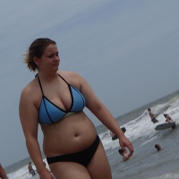 Big boobed girl on the beach in blue and black bikini Big boobed beach babe
