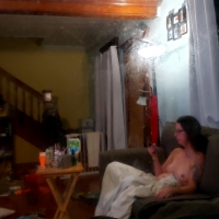 Peeping Tom pics of a nude girl on the couch watching TV Peeping Tom naked girl