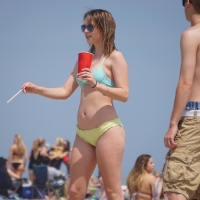 Sexy beach babe in yellow and blue bikini with friends Sexy beach girl in yellow and blue