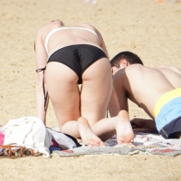 Sexy girl on the beach laying out and bending over in her bikini Bent over beach girl