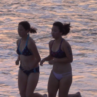 Asian girl and friend running on the beach