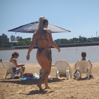 Tattooed big booty babe on the beach in a thong bikini Tattooed big booty beach babe