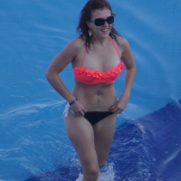 Sexy red haired girl in pink and black bikini at the pool Sexy girl in pink and black