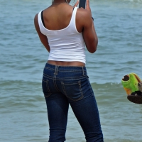 Black girl with a nice body in tight jeans on the beach Black girl in jeans on the beach