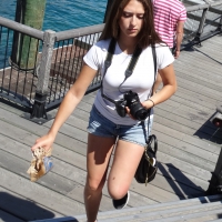 Pretty girl with a camera in little denim shorts Pretty photographer in shorts