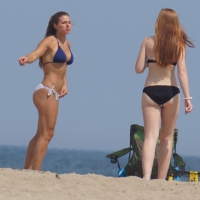 Redhead and brunette friends looking sexy in bikinis on the beach Redhead and brunette friend on the beach