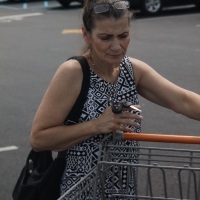 Old lady in the parking lot leaving the grocery store Old lady leaving the grocery store