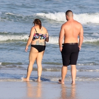 Thick flat assed tattooed lady on the beach in a bikini Thick tattooed lady