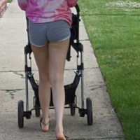 Milf with a nice ass in grey shorts pushing the stroller Milf in grey shorts