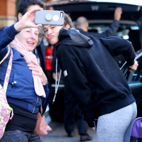 Zendaya taking a selfie with a fan while in grey leggings in New York City 07.jpg